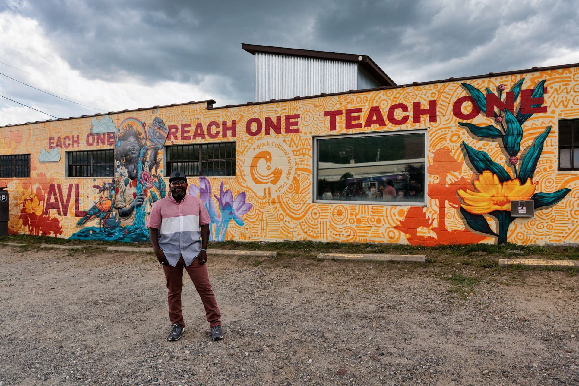 Artist Tommy Lee McGee standing in front of Black Girl Magic, his artwork commission by Explore Asheville. Photo Credit: Reggie Tidwell.
