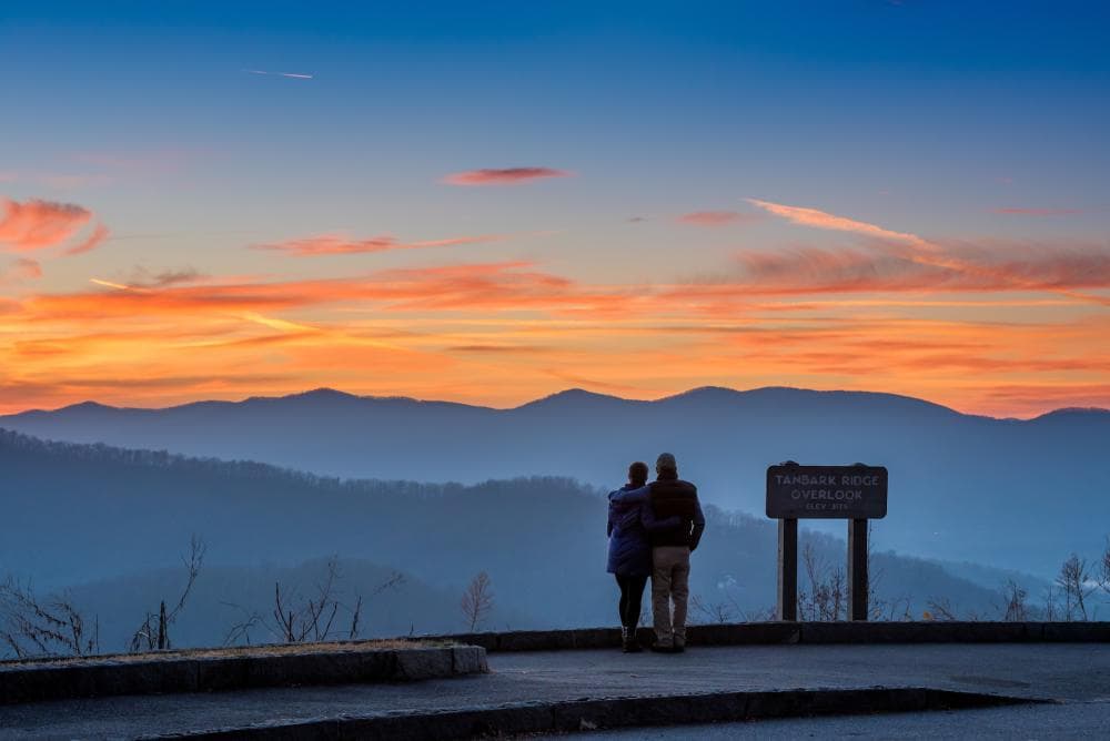 A couple enjoys a mountain vista on the Blue Ridge Parkway near Asheville, NC A couple enjoys a mountain vista on the Blue Ridge Parkway near Asheville, NC