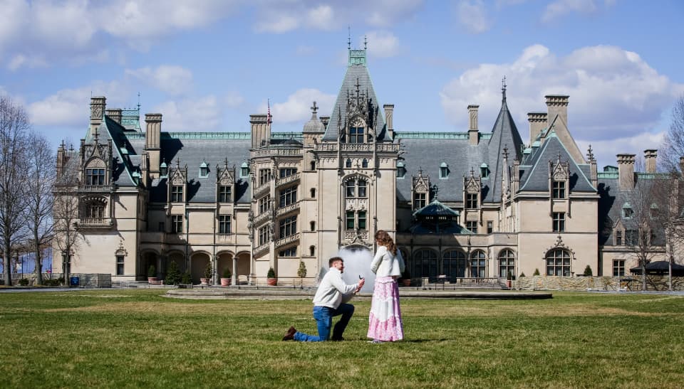 A couple is photographed in front of the Biltmore House during a Marriage Proposal A couple is photographed in front of the Biltmore House during a Marriage Proposal