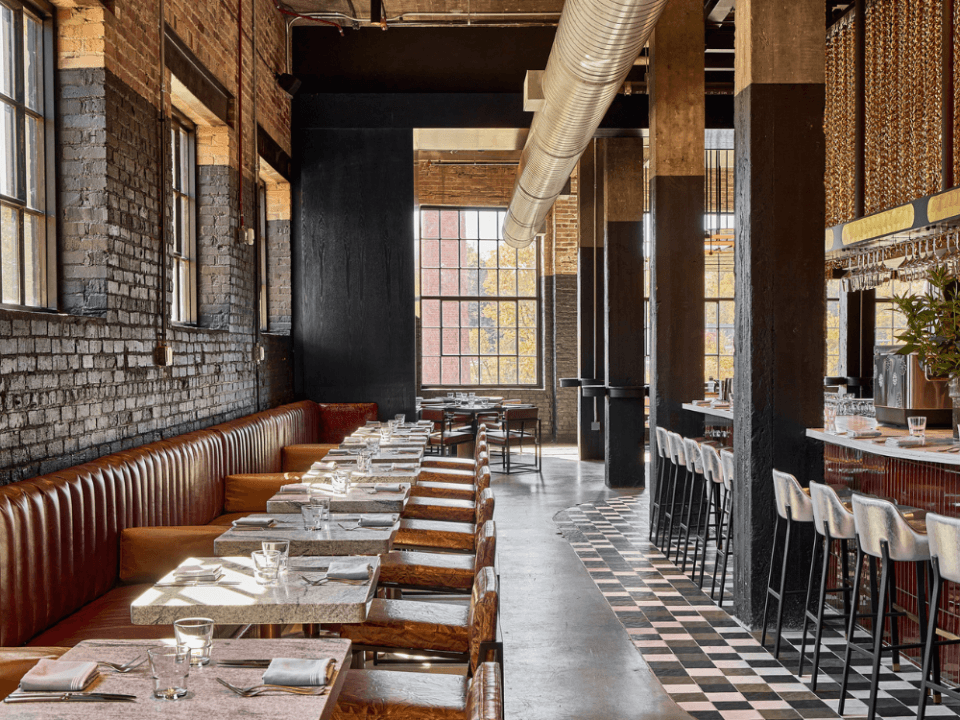 restaurant with large windows, black painted brick walls, and checkered floors restaurant with large windows, black painted brick walls, and checkered floors