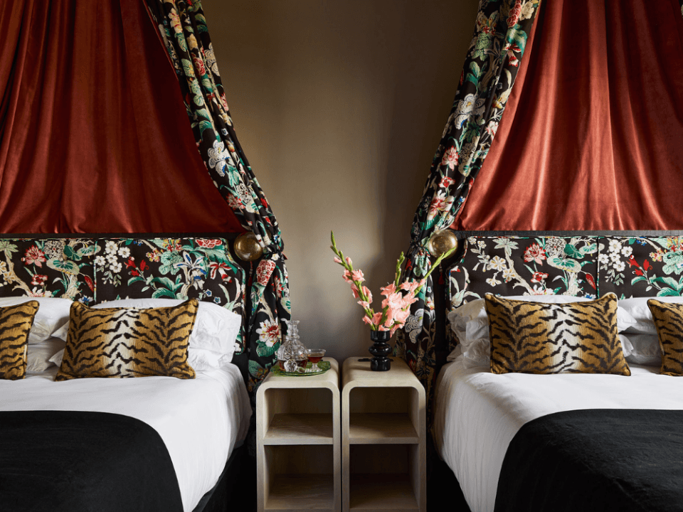two queen beds with elaborate canopies and tiger pattern pillows two queen beds with elaborate canopies and tiger pattern pillows