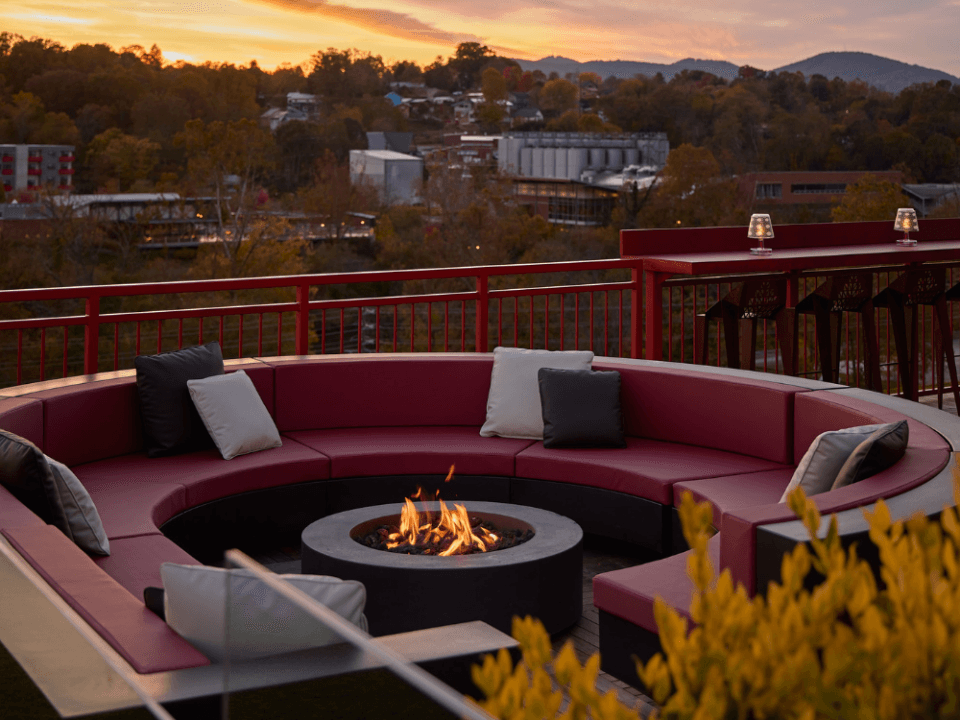 fire pit and red conversation couch on a rooftop bar with the sun set in the background fire pit and red conversation couch on a rooftop bar with the sun set in the background
