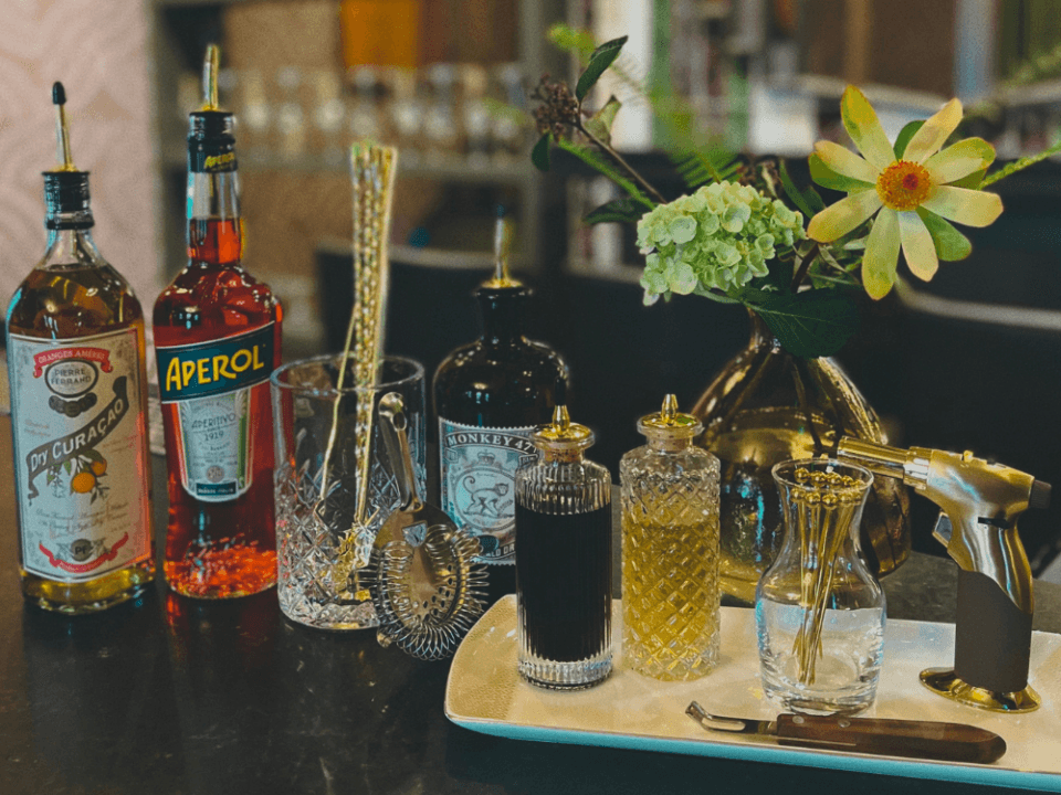 spirits and mix-ins lined up on a bar with crystal shakers and accessories spirits and mix-ins lined up on a bar with crystal shakers and accessories