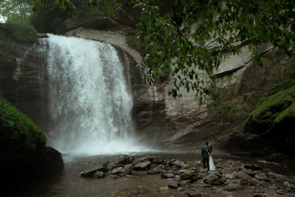 A married couple admiring a waterfall together after eloping. A married couple admiring a waterfall together after eloping.