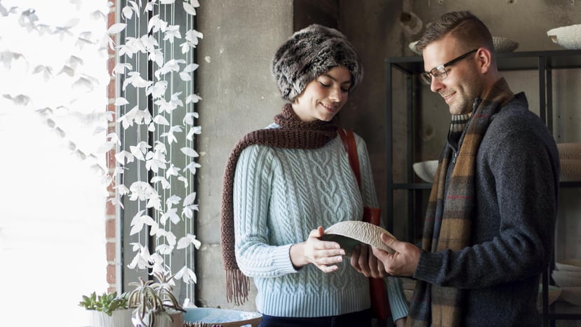 Two artists hold a ceramic bowl in Asheville